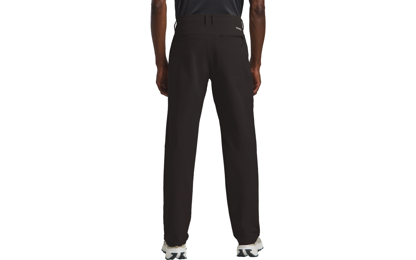 Person von hinten, trägt schwarzen Pullover und schwarze Hose