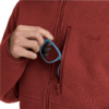 Hand hält blaue Sonnenbrille in geöffneter Brusttasche eines roten, gerippten Reißverschluss-Pullovers