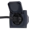 Dark gray square electrical outlet with open hinged cover, black plug inserted, cable extending to the left