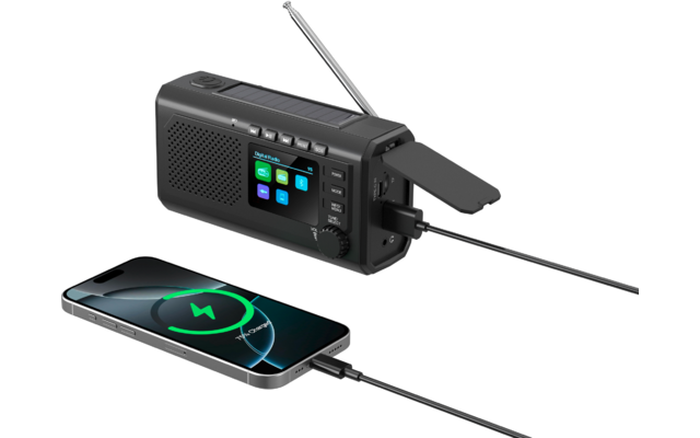 Schwarzes tragbares Radio mit ausgeklapptem Solarpanel und Antenne, per Kabel mit einem Smartphone verbunden; auf dem Smartphone-Bildschirm ist ein Ladesymbol