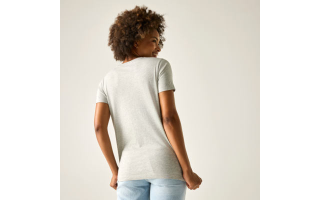 Person von hinten, trägt hellgraues T-Shirt mit kurzen Ärmeln und hellblaue Jeans, lockige dunkle Haare, schaut über die rechte Schulter, heller einfarbiger Hintergrund