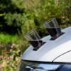 Zwei Gläser mit rotem Getränk stehen auf der Motorhaube eines silbernen Autos