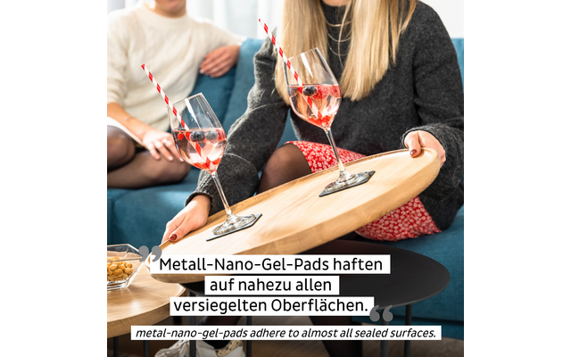 Zwei Frauen sitzen auf einem Sofa und halten ein Tablett mit zwei Gläsern und Strohhalmen