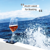 Weinglas mit rosa Wein auf der Reling eines Bootes mit Meer und Wellen im Hintergrund