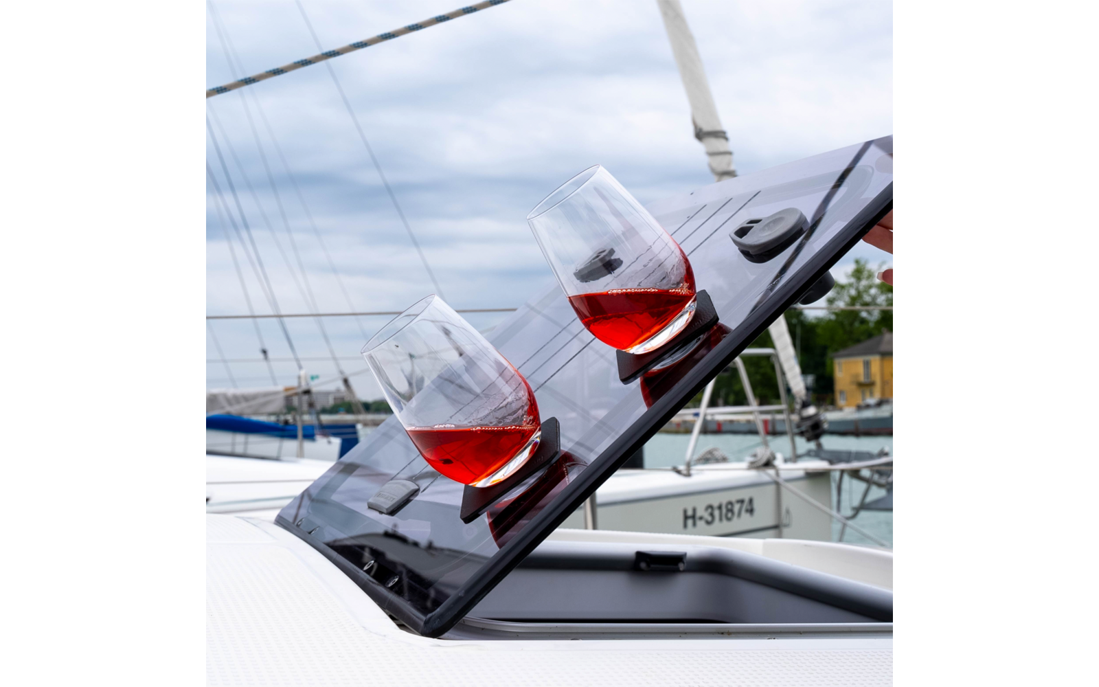 Deux verres avec boisson rouge sur une trappe ouverte d'un bateau dans le port