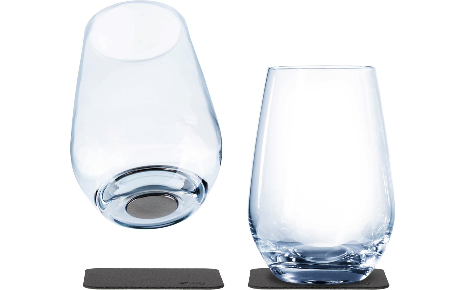 Deux verres transparents sur des dessous de verre noirs, l'un debout et l'autre couché sur le côté