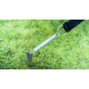 Spring tensioner attached to a black strap, fixed to the ground in the grass