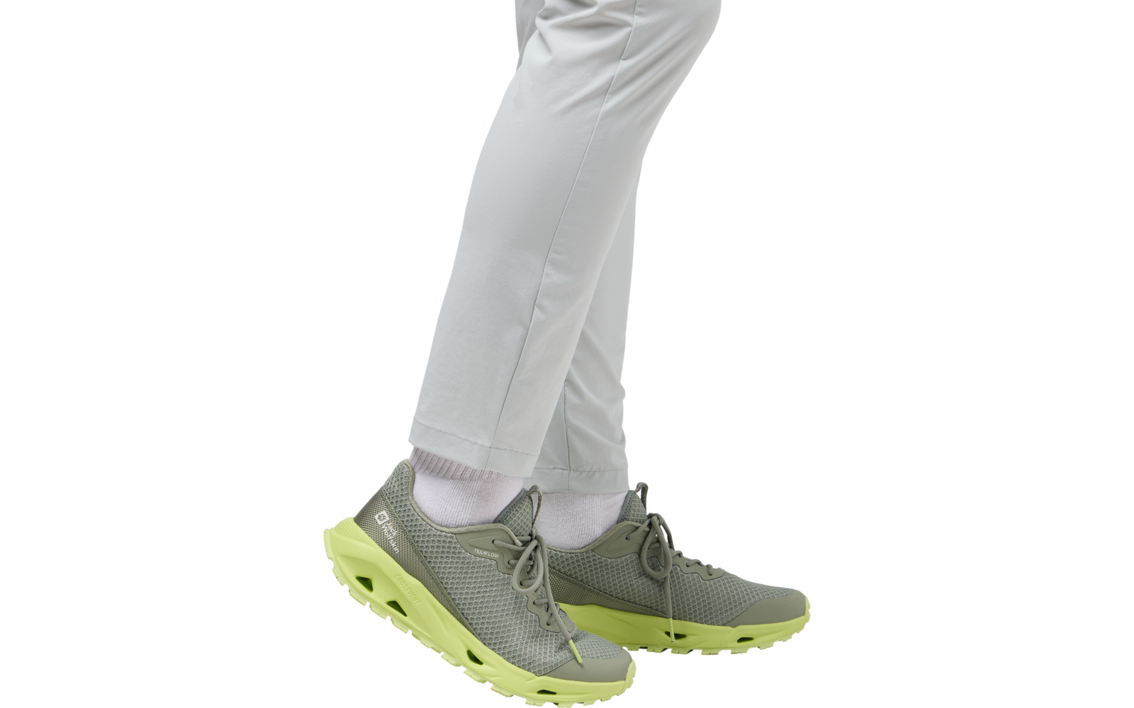 Beine in weißen Hosen und grauen Sportschuhen mit gelber Sohle