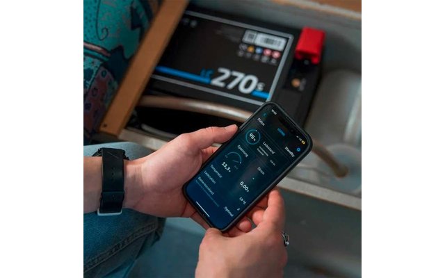 Hand hält ein Smartphone mit einer App, im Hintergrund eine elektronische Waage mit Anzeige 270 kg