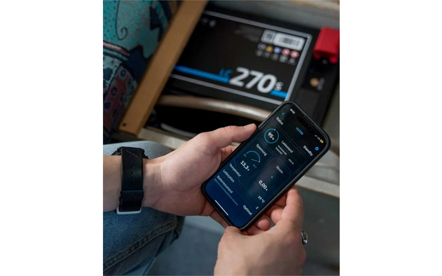 Main tenant un smartphone avec une application, balance électronique affichant 270 kg en arrière-plan