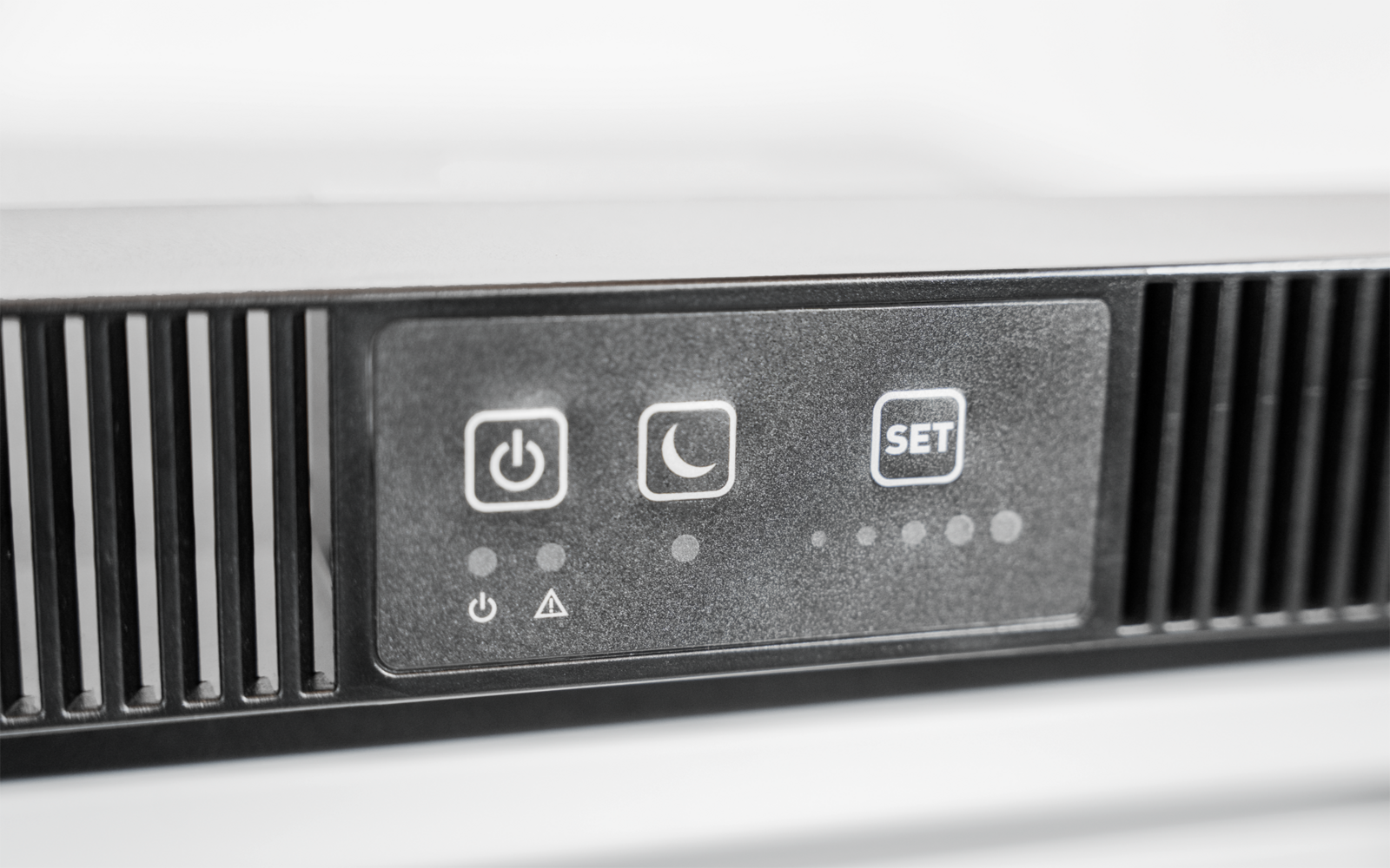 Schwarzes Bedienfeld mit drei Symbolen (Ein/Aus, Mond, 'SET'), fünf kleinen Kontrollleuchten und Lüftungsschlitzen links und rechts