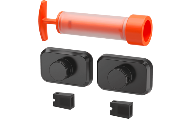 Orange tubular hand pump above two black rectangular pieces with circular protrusions and two small black rectangular inserts
