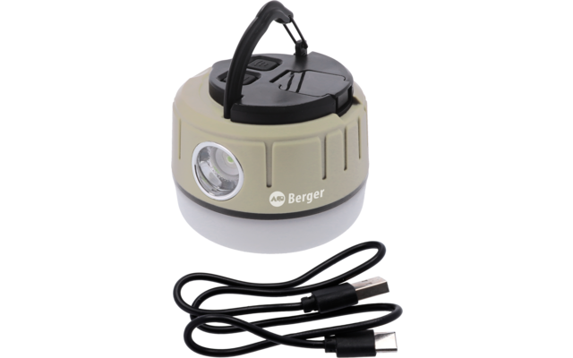 Runde, kompakte Leuchte mit beige-braunem Gehäuse, schwarzem Klappgriff oben, seitlicher LED-Linse, weißer Diffusorring am Boden und 'Berger'-Logo auf der Seite