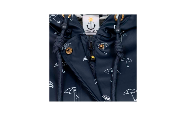 Donkerblauwe jas met wit paraplu‑patroon, centrale rits, koord met stopper, goudkleurige drukknop en wit label met ankerlogo en gele ster