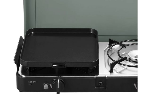 Gasherd mit flacher schwarzer Grillplatte links, offenem Gasbrenner mit Metallgitter rechts und zwei Drehreglern an der Vorderseite