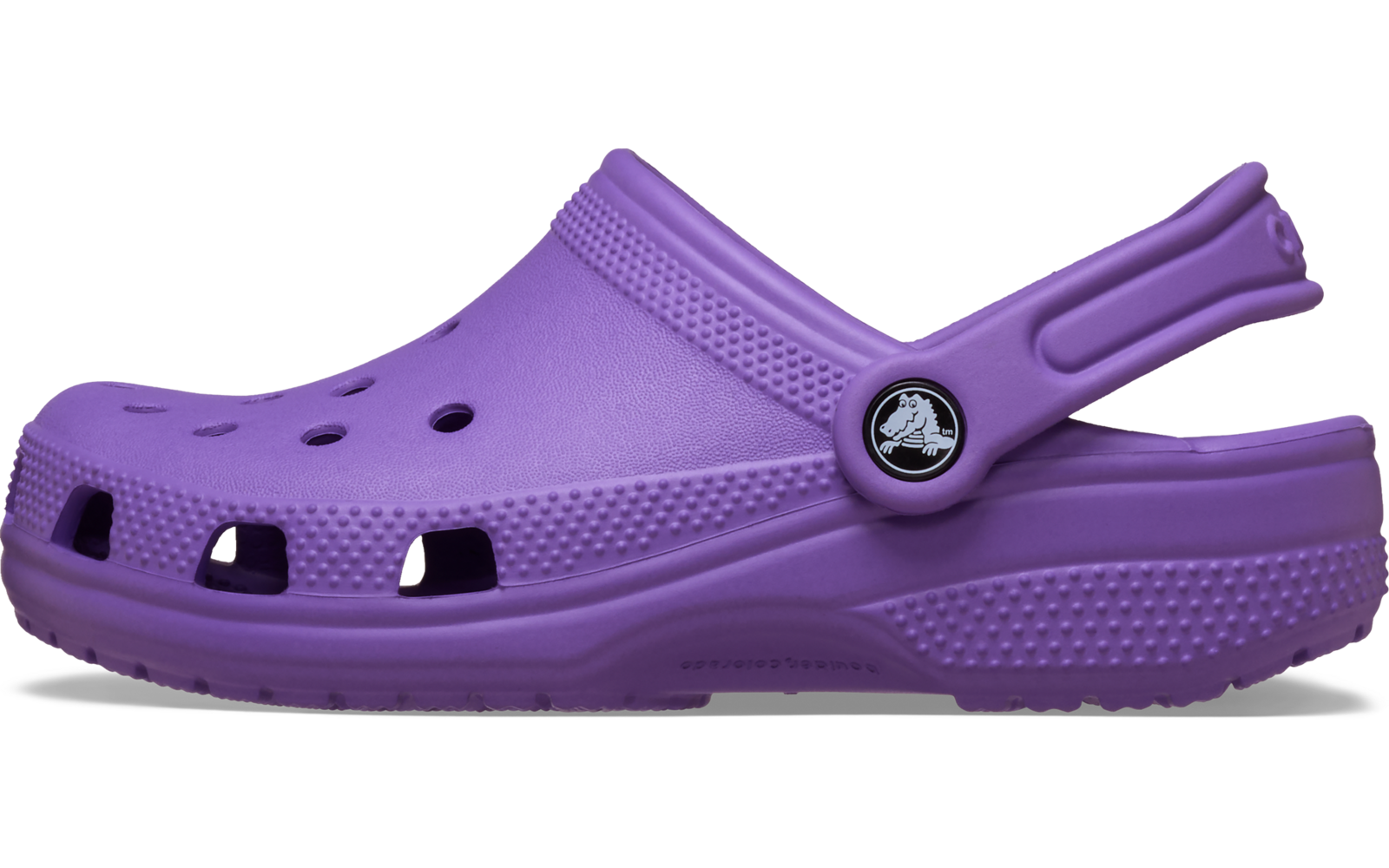 Une mule violette seule, vue de côté, avec des trous d'aération, bride arrière avec bouton rond et semelle texturée