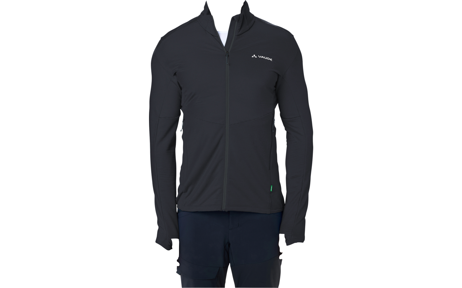 Person mit kurzem Haar steht frontal vor weißem Hintergrund, trägt schwarze, enganliegende Jacke mit Reißverschluss und kleinem weißen Logo auf der linken Brust, weißes T‑Shirt am Kragen sichtbar, dunkle Hose, Hände seitlich