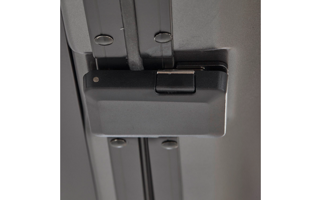 Nahaufnahme eines grauen Gehäuses mit kleinem rechteckigen Verschluss auf zwei silbernen Metallschienen, mehrere sichtbare Schraubenköpfe