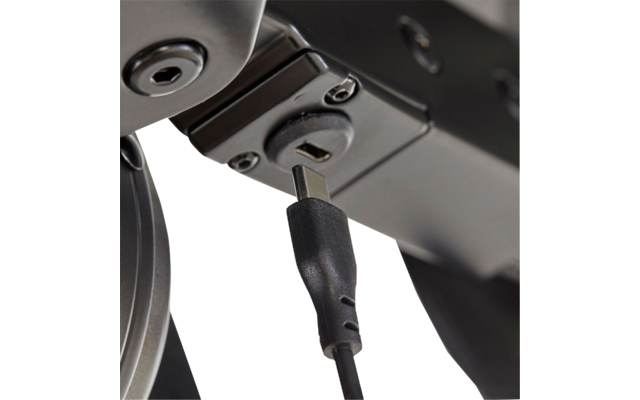 Nahaufnahme eines schwarzen Kabels mit rechteckigem Metallstecker, eingesteckt in eine Buchse an einem schwarzen Metallgehäuse