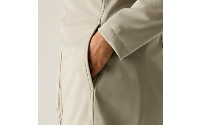 Hand in der Seitentasche eines hellbeigen Mantels, Ärmel und Seitennaht sichtbar