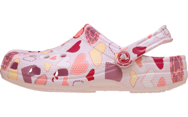 Sabot rose avec motif de cœurs multicolores, trous d'aération sur l'empeigne, bride arrière avec bouton rond et semelle rose pâle