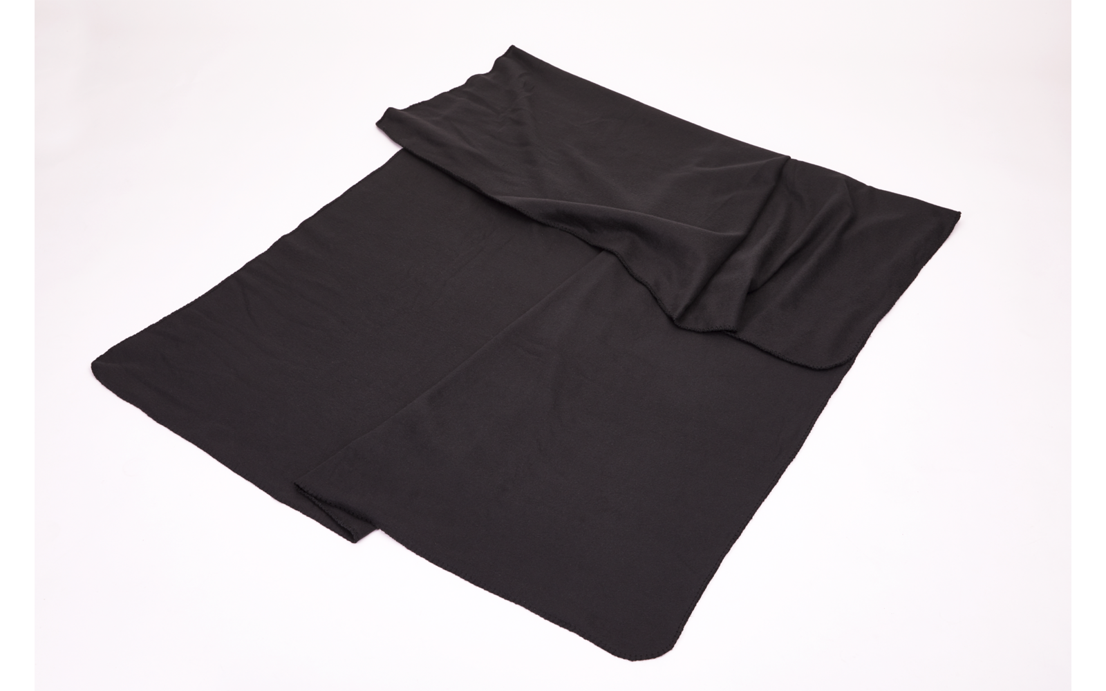 Ein schwarzes, rechteckiges Tuch liegt auf einer weißen Oberfläche, eine Ecke ist leicht umgeschlagen