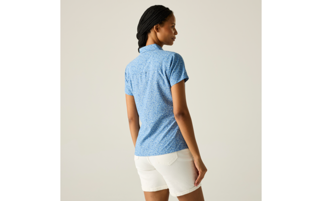 Person von hinten, trägt blaues kurzärmliges gemustertes Poloshirt und weiße Shorts, Haare zu Zöpfen geflochten, Blick nach rechts vor einfarbigem Hintergrund