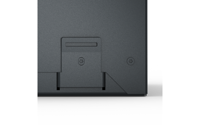 Surface gris foncé avec deux vis en forme d'étoile, une trappe rectangulaire avec une fente étroite, un coin inférieur droit biseauté et un fond clair en dessous