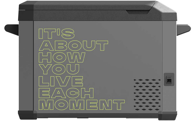Seitenansicht eines grauen tragbaren Kühlers mit hellgrüner Schrift 'IT'S ABOUT HOW YOU LIVE EACH MOMENT', seitlichen Griffen, Lüftungsschlitzen und einem Bedienelement rechts