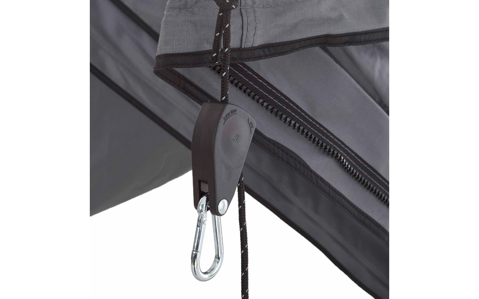 Graues Gewebe mit Reißverschluss, schwarzes Seil durch eine schwarze Kunststoffrolle, daran ein silberner Karabinerhaken; Metallstreben im Hintergrund