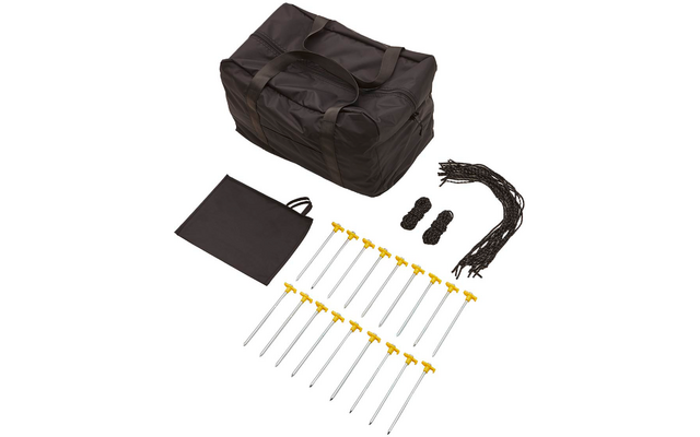 Große schwarze Tasche mit Griffen; mehrere silberne Metallstangen mit gelben T-Griffen; mehrere gebündelte schwarze Seile; rechteckiges schwarzes Textilstück mit Schlaufe auf weißem Hintergrund