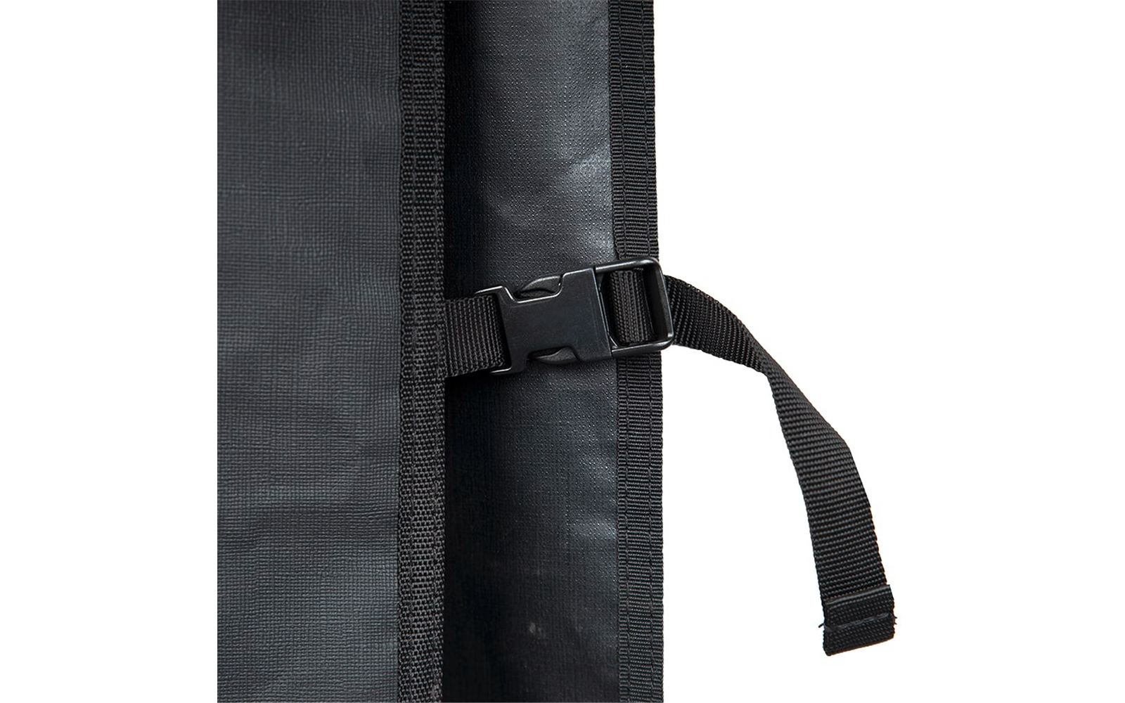 Nahaufnahme einer schwarzen Steckschließe mit Gurt und losem Gurtende auf schwarzem, leicht strukturiertem Gewebe