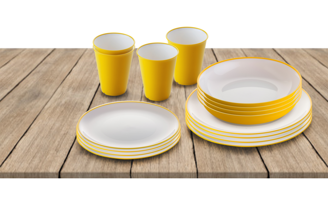 Verschillende witte borden en gele bekers op een houten tafel