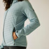 Personne portant une veste matelassée bleu clair, buste et bras visibles