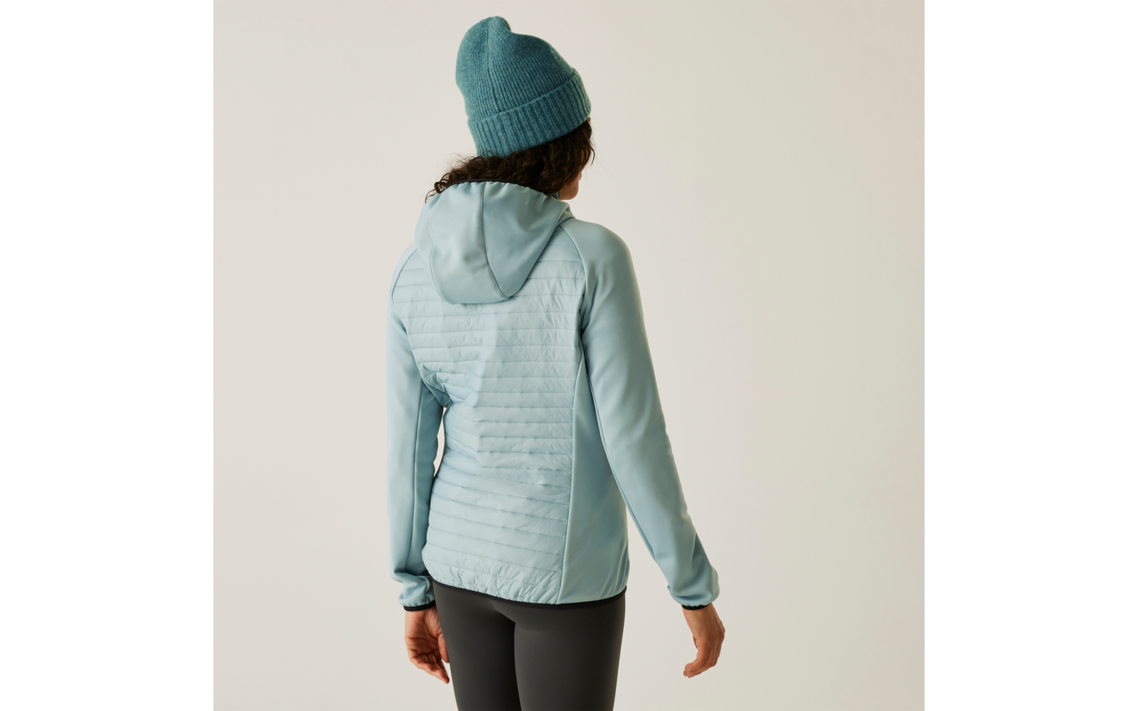 Femme vue de dos portant un bonnet bleu et un sweat à capuche bleu