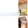 White storage container mounted on the wall inside a camper van with wine glasses and flowers in the background