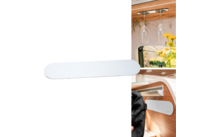 Weißer Aufbewahrungsbehälter an der Wand in einem Wohnmobil mit Weingläsern und Blumen im Hintergrund