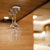 Two upside-down wine glasses hanging on a wooden wall