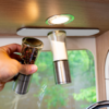 Hand holding pepper grinder next to a salt grinder under a kitchen light