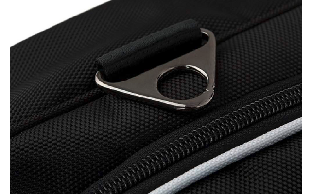 Nahaufnahme eines schwarzen, strukturierten Stoffs mit Reißverschluss, weißem Streifen, dreieckigem Metallbeschlag mit rundem Loch und kurzer Stoffschlinge