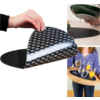 Hand lifting black flexible mat with white pattern, second hand holding green plate, person holding snack tray with glasses and orange juice