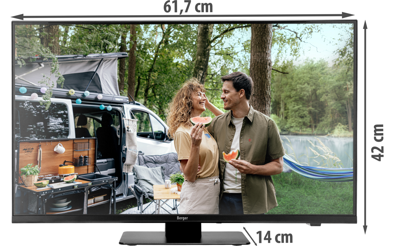 Zwei Erwachsene stehen vor einem geöffneten Campervan im Wald und halten jeweils ein Stück Wassermelone; neben dem Van hängt eine Hängematte, im Van ist eine Campingküche sichtbar