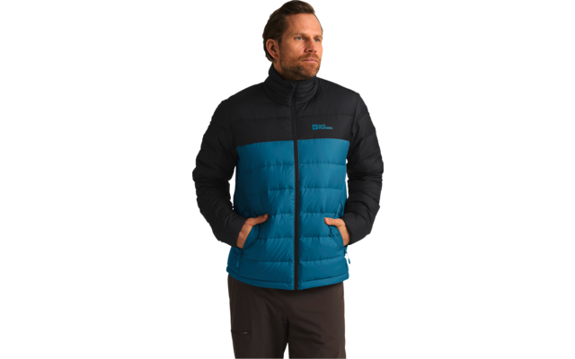 Mann mit braunen Haaren und Bart trägt eine blaue und schwarze Daunenjacke