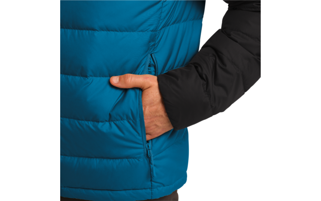 Hand in der Tasche einer blauen Steppjacke