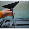 Hand hält ein Messgerät mit Trichter über einem Autoarmaturenbrett