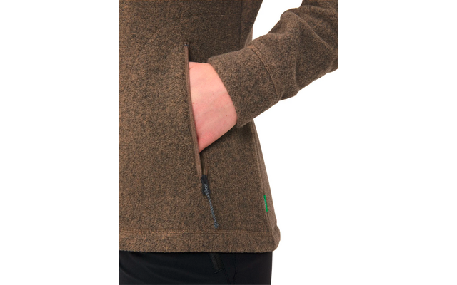 Person trägt eine braune Jacke, eine Hand steckt in einer seitlichen Reißverschlusstasche