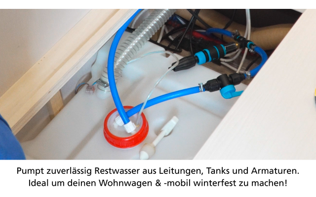 Scompartimento in legno aperto con un contenitore di plastica bianco con tappo a vite rosso, un tubo blu e un tubo bianco inseriti; tubo corrugato grigio, pinza con impugnature nero-blu, raccordi metallici e piccoli pezzi