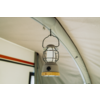Een hangende lantaarn met metalen kooi aan een haak aan het tentdak; lichtgekleurde tentbinnenkant, zichtbare tentstok en een rechthoekig raam met een zwarte en rode streep