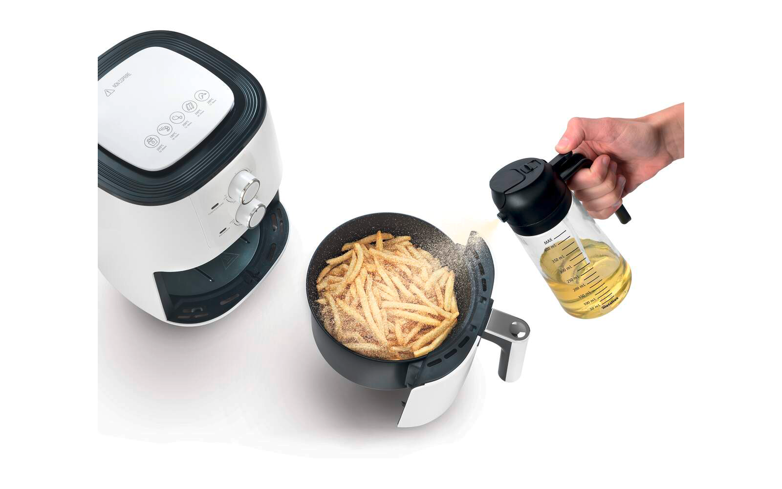 Weiße Heißluftfritteuse mit offenem Korb voller Pommes, Hand gießt Öl aus Glaskaraffe