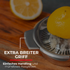 Demi-citron sur un presse-agrumes en métal posé sur une planche en bois; une autre moitié de citron en arrière-plan; texte superposé : 'EXTRA BREITER GRIFF' et 'Einfaches Handling und müheloses Ausgießen'